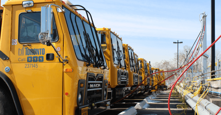 A line of City of Toronto trucks being refuelled at a compressed natural gas station.