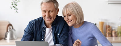 Happy pensioners sittting in front of computer.