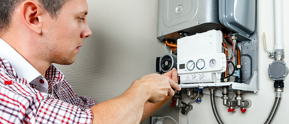 Plumber attaches trying to fix the problem with the residential heating equipment. 