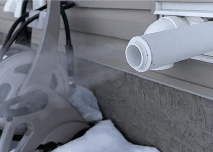 Modern high efficiency furnaces vent through PVC piping near the home's foundation.
